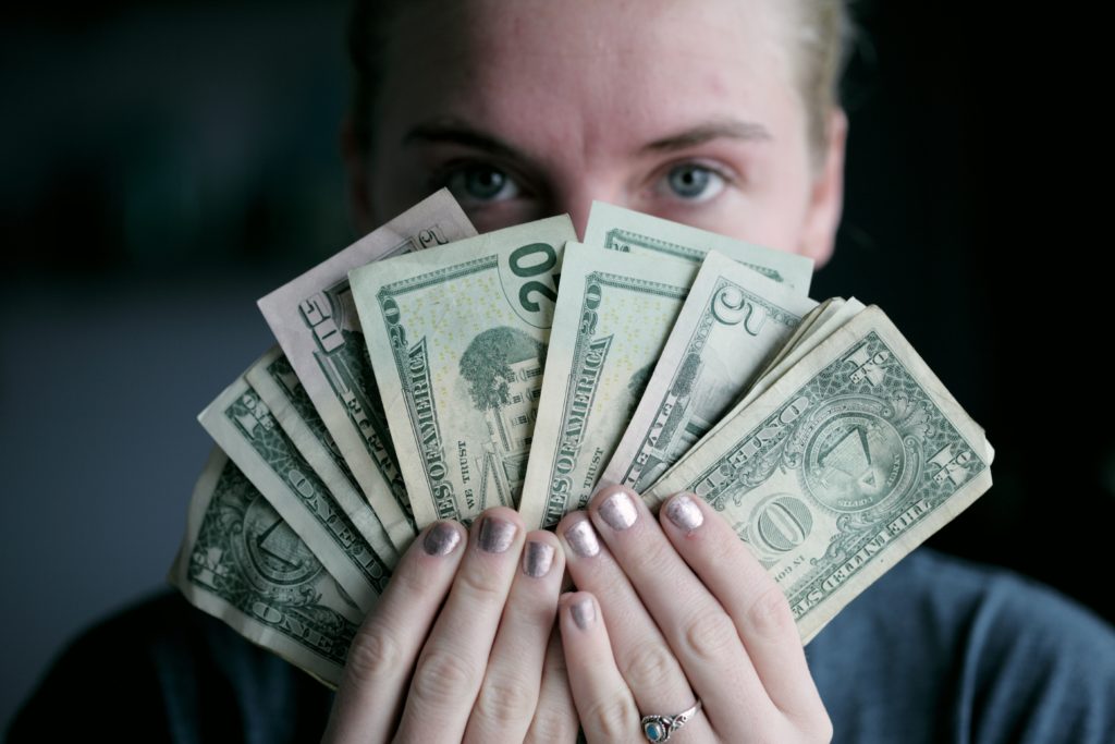 A woman holding a fan of paper money